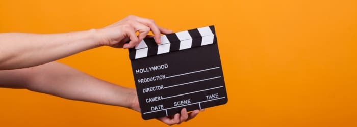 Photo of movie production clapper board isolated in studio over yellow background. Film accessory isolated.